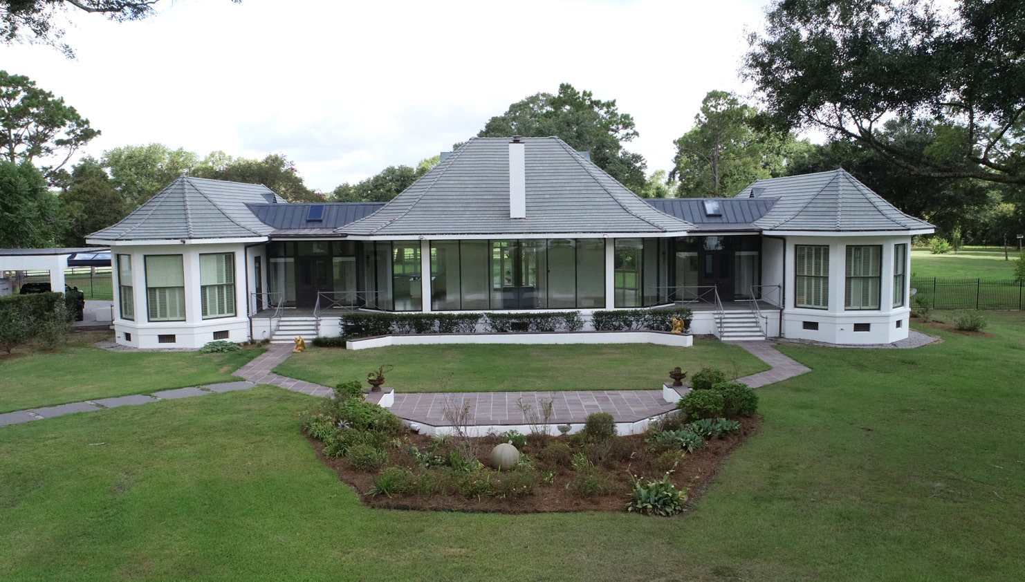The main residence with its glazed rear elevation and formal garden